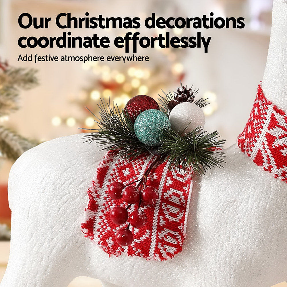 Christmas decoration with red and white patterned ribbon and greenery on a blurred festive background.