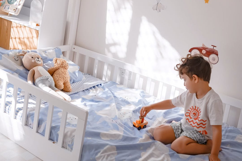 Young child playing on white wooden bed