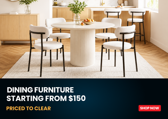 A dining room scene showing a round off-white dining table with six upholstered chairs in white and black, set on a light rug in a modern interior. A dark blue banner at the bottom reads 'DINING FURNITURE STARTING FROM $150 PRICED TO CLEAR' with a red 'SHOP NOW' button.