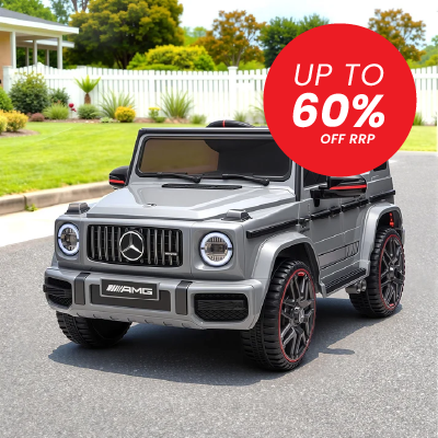 A gray Mercedes-Benz AMG-style ride-on toy car parked on a driveway in front of a suburban house and white fence. A large red circular sale badge reading 'UP TO 60% OFF RRP' is overlaid on the upper right.