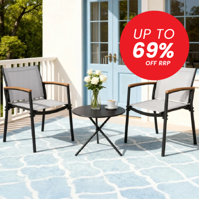 A 3-piece outdoor patio furniture set featuring two gray mesh armchairs with brown wooden armrests and a small round black metal side table, arranged on a blue patterned rug in front of a white house with blue doors. A red circular promotional badge reading 'UP TO 69% OFF RRP' is in the top right corner.