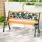 Wooden bench with floral designs on a patio
