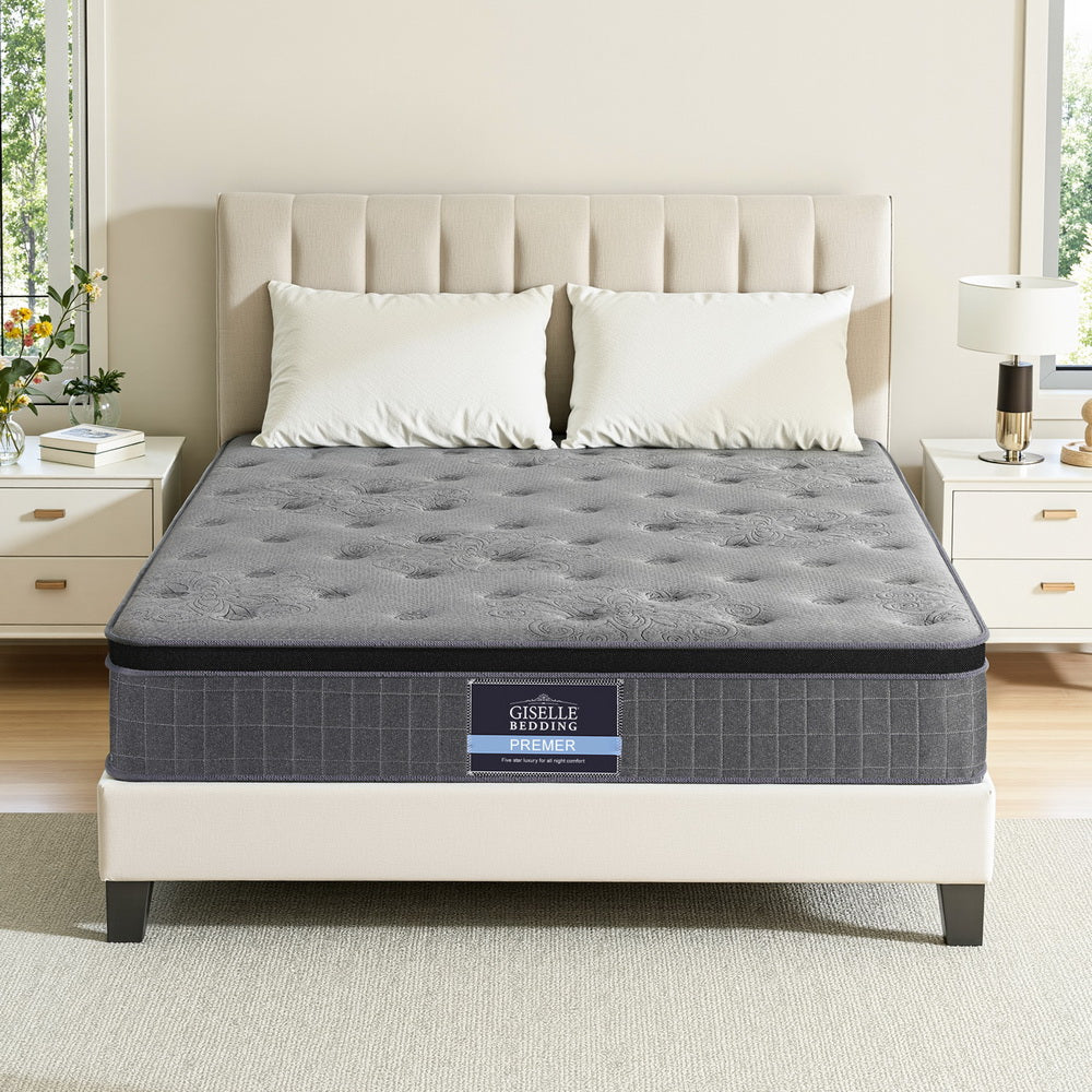 Gray mattress on a bed with a beige headboard in a bedroom setting