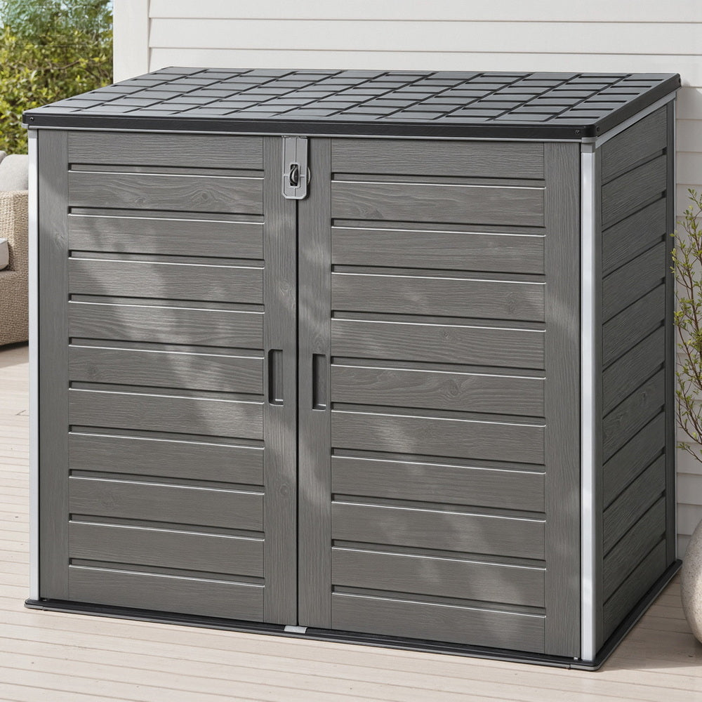 Gray outdoor storage shed with a tiled roof on a wooden deck.