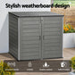 Gray outdoor storage shed with weatherboard design, lockable feature, and indoor/outdoor use, set against a garden background.