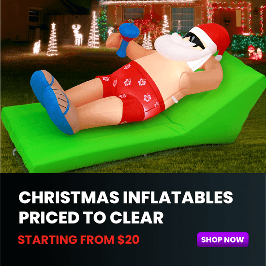 Inflatable Santa Claus on a green air mattress with Christmas decorations in the background.