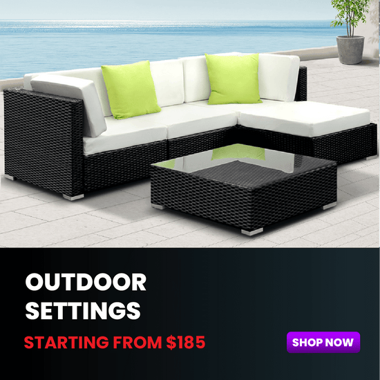 Outdoor patio furniture set with black frame and white cushions, featuring green pillows.