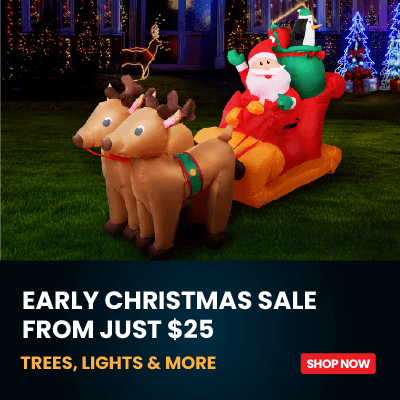 Inflatable Christmas outdoor decoration featuring Santa Claus in a red sleigh pulled by two brown reindeer, displayed on a lawn at night with holiday trees and lights in the background. A dark promotional banner at the bottom reads 'EARLY CHRISTMAS SALE FROM JUST $25' and 'TREES, LIGHTS & MORE' with a red 'SHOP NOW' button.