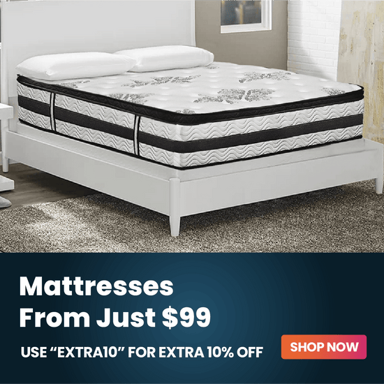 A white upholstered bed with a patterned mattress shown in a bedroom setting, with a dark promotional banner at the bottom reading 'Mattresses From Just $99' and 'SHOP NOW'.