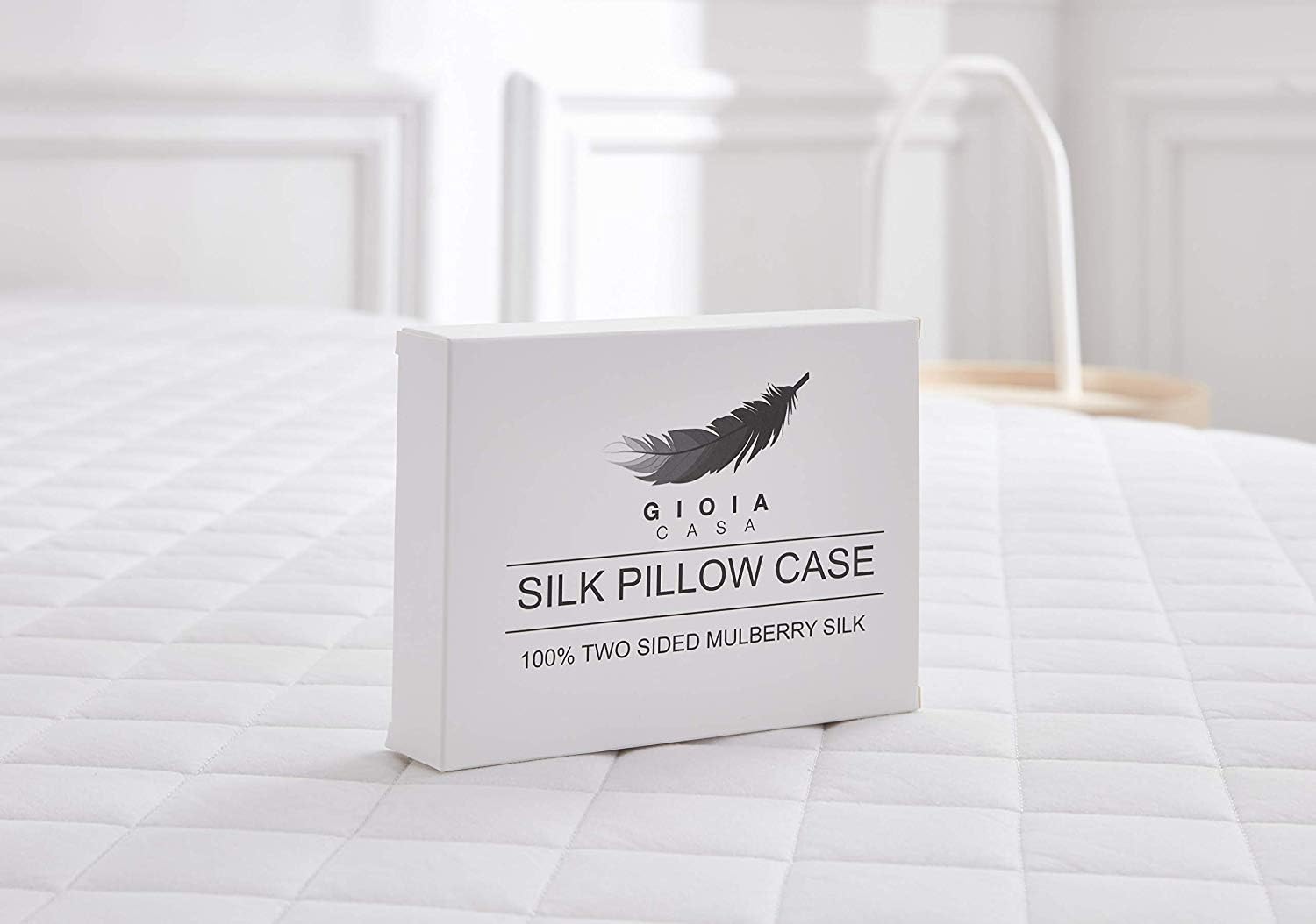 Silk pillow case packaging on a bed with a feather design logo.
