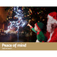Santa Claus and a child with a lit reindeer decoration, Christmas tree in the background.